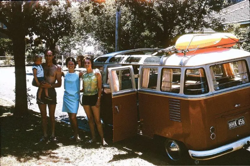 VW Bus with family standing in front